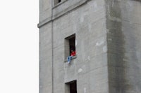 a man sitting in a window of a tall building