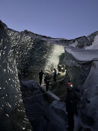 a group of people walking through an ice cave