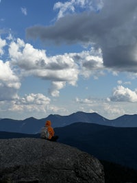 a person sitting on top of a rock